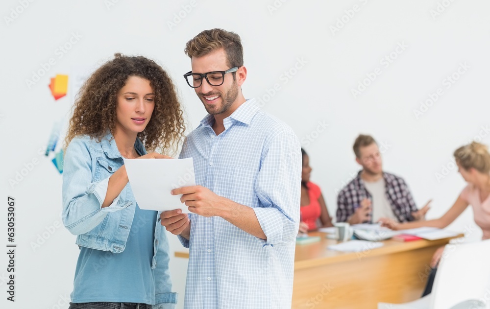 Attractive designers looking at digital tablet together Attractive designers looking at digital tablet together