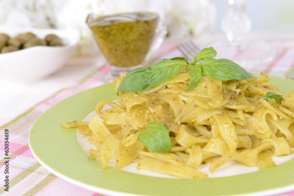 Delicious pasta with pesto on plate on table close-up Delicious pasta with pesto on plate on table close-up