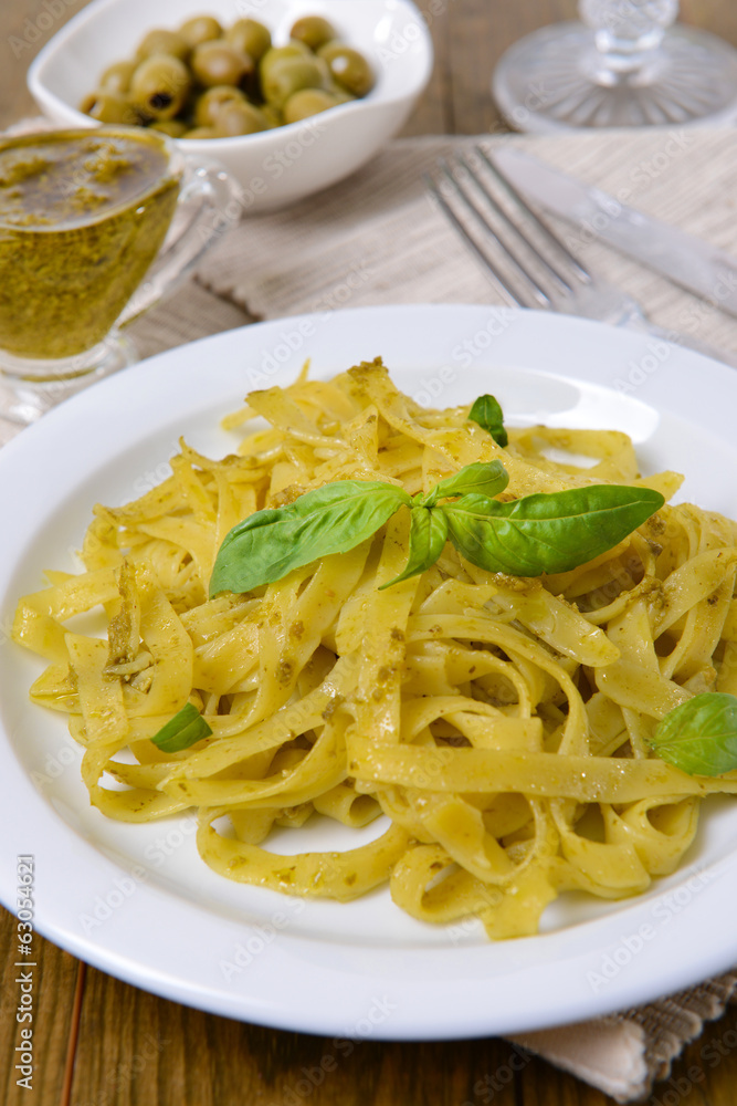 Delicious pasta with pesto on plate on table close-up Delicious pasta with pesto on plate on table close-up