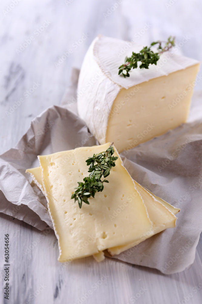 Tasty Camembert cheese with thyme, on wooden table