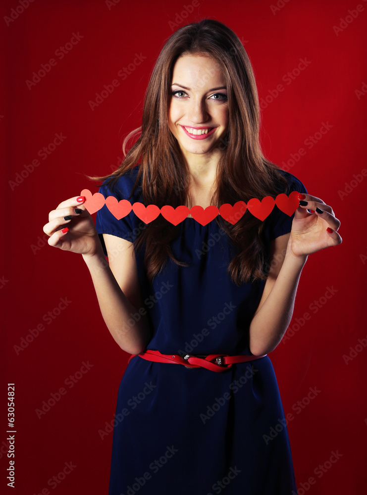 Naklejka premium Attractive woman with with paper garland, on color background