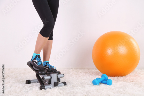 Young beautiful fitness girl exercising on stepper in gym photo