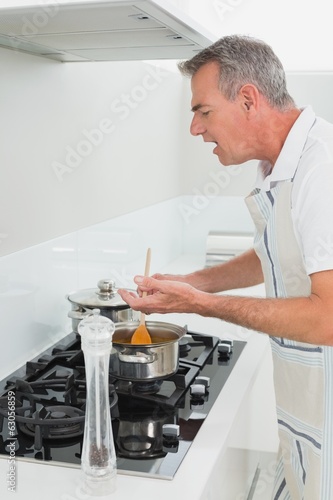 Side view of a man preparing food in kitchen