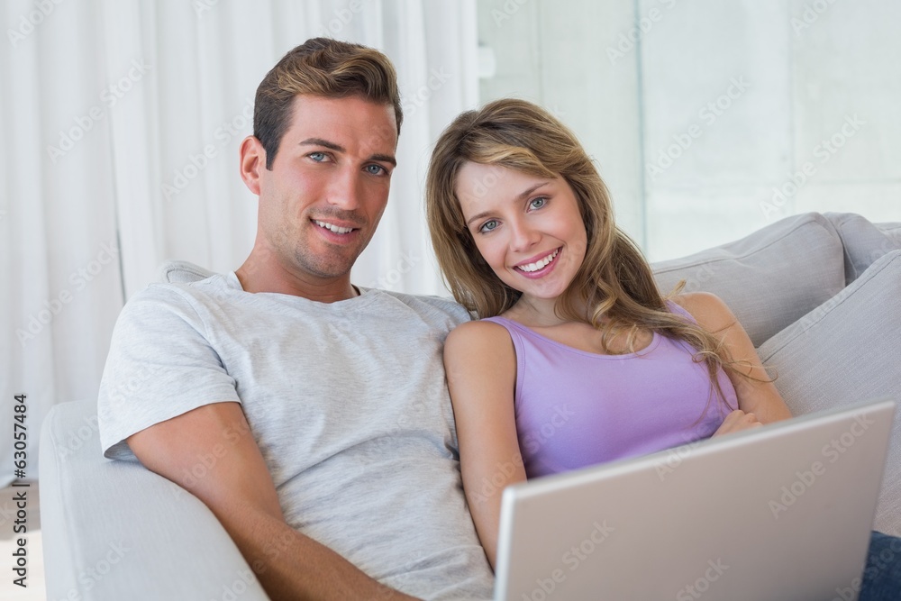 Relaxed couple using laptop on couch Relaxed couple using laptop on couch