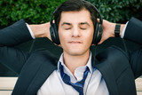 Businessman is relaxing in headphones