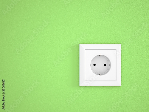 simple white electric socket on green wall