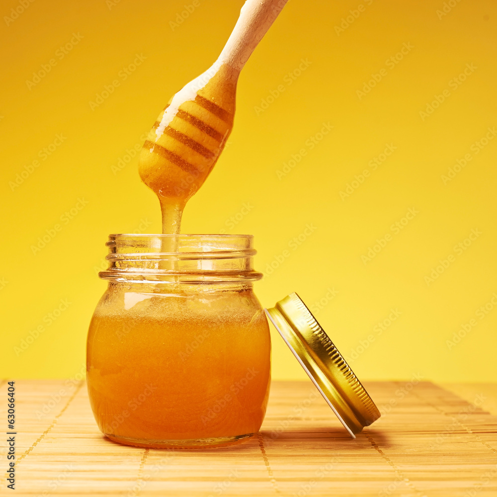 Honey jar with wooden dipper composition Honey jar with wooden dipper composition