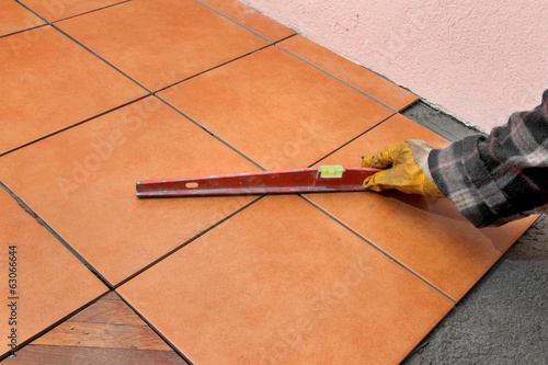 Home renovation, worker control tiles with level tool photo