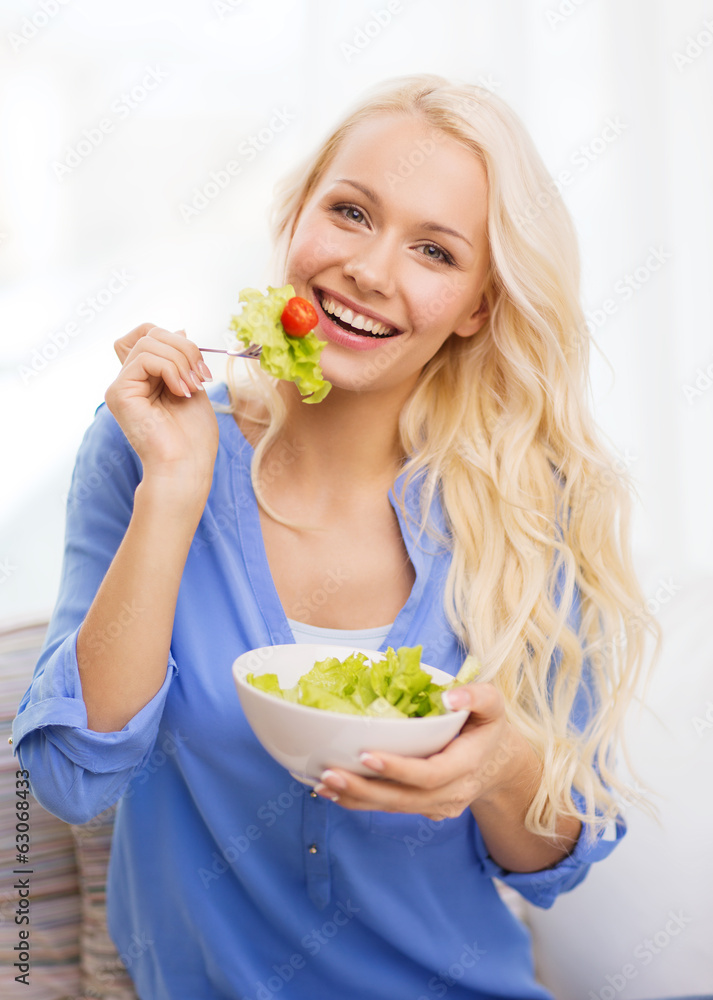 smiling young woman with green salad at home smiling young woman with green salad at home
