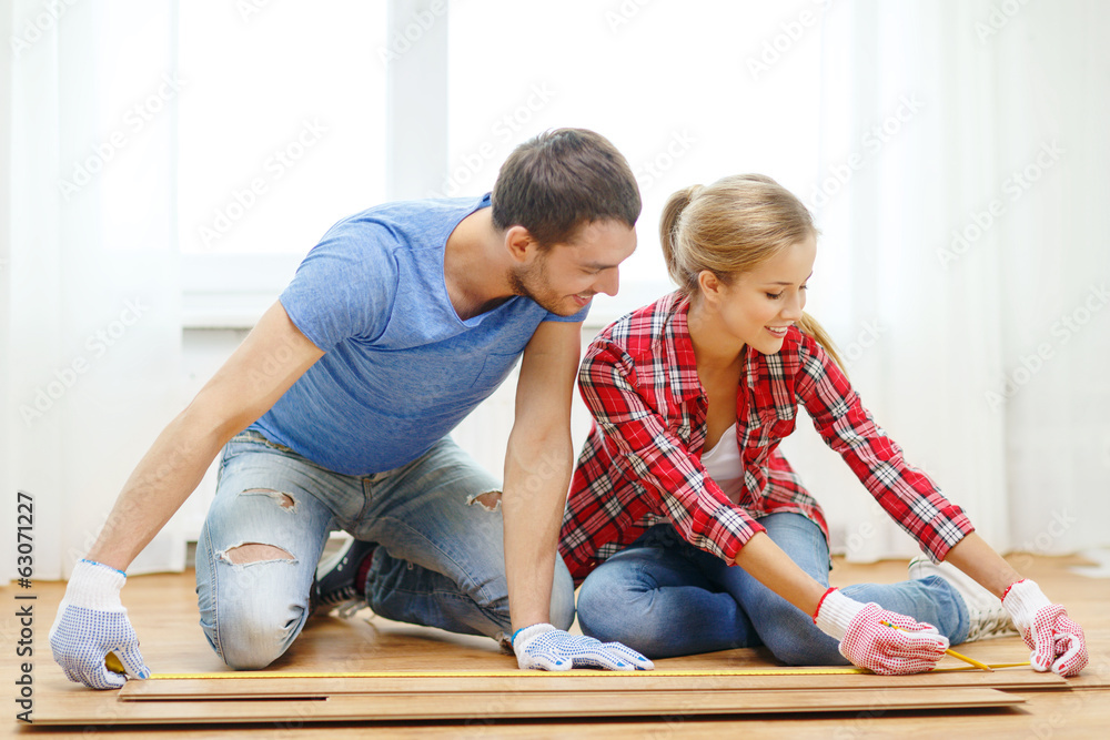 Fototapeta premium smiling couple measuring wood flooring