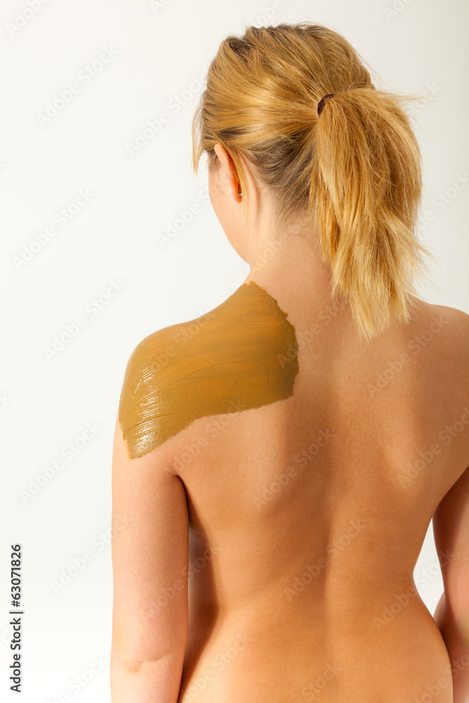 Fototapeta premium Die junge nackte Frau wird mit Heilerde behandelt