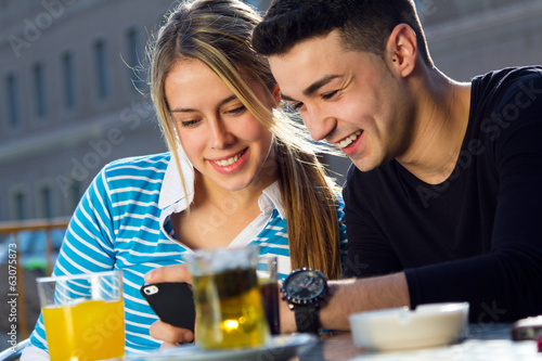 Young couple having fun with smartphones