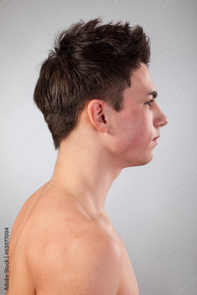 Handsome face of a young man on grey Handsome face of a young man on grey