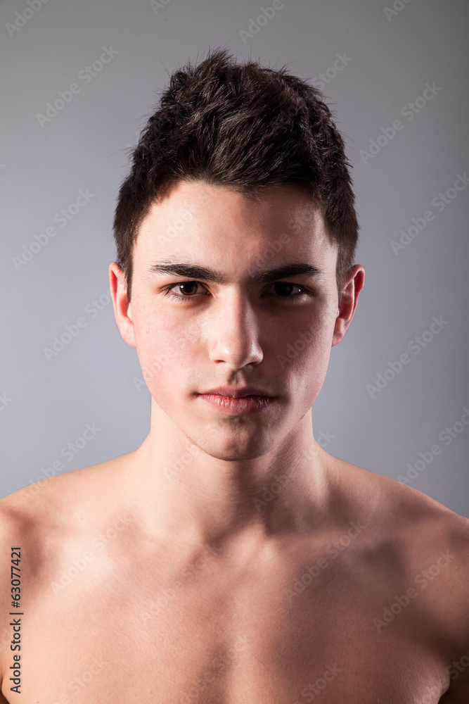Handsome face of a young man on grey Handsome face of a young man on grey