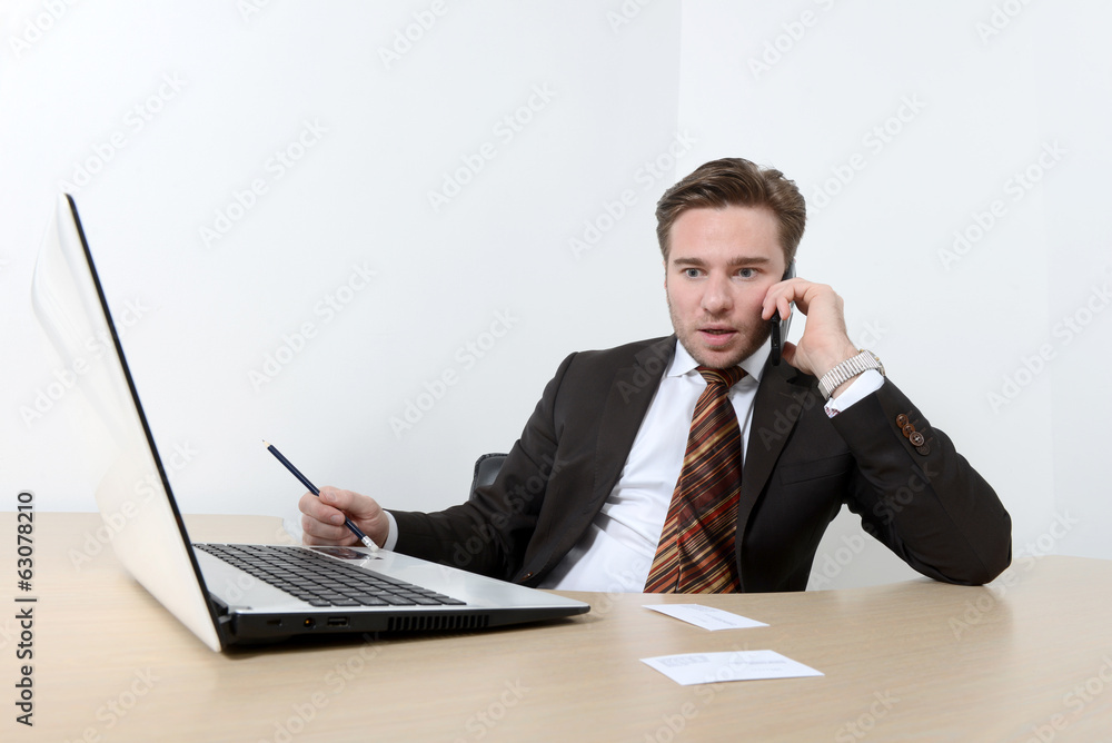 Surprised young businessman talking on the mobile phone Surprised young businessman talking on the mobile phone