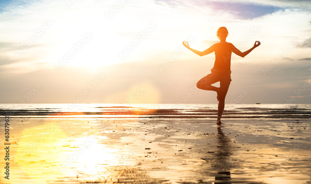 Silhouette young woman practicing yoga on the beach at sunset. Silhouette young woman practicing yoga on the beach at sunset.