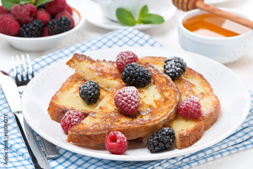 French toast with berries and powdered sugar on a plate
