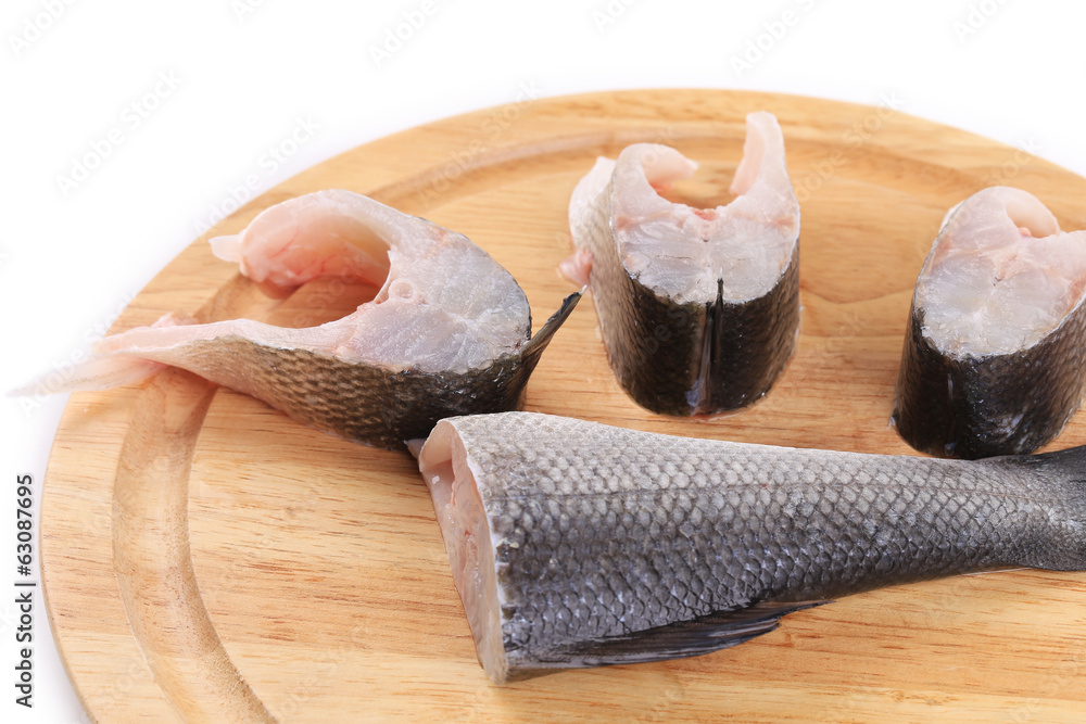Steaks and tail of seabass on wooden platter. Steaks and tail of seabass on wooden platter.