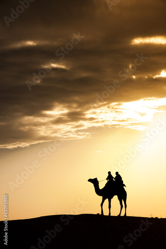 A desert local walks with camel through Thar Desert