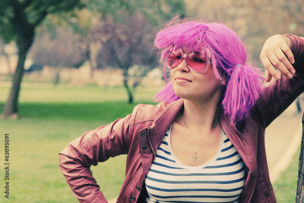 beautiful young woman with pink sunglasses and purple hair stand