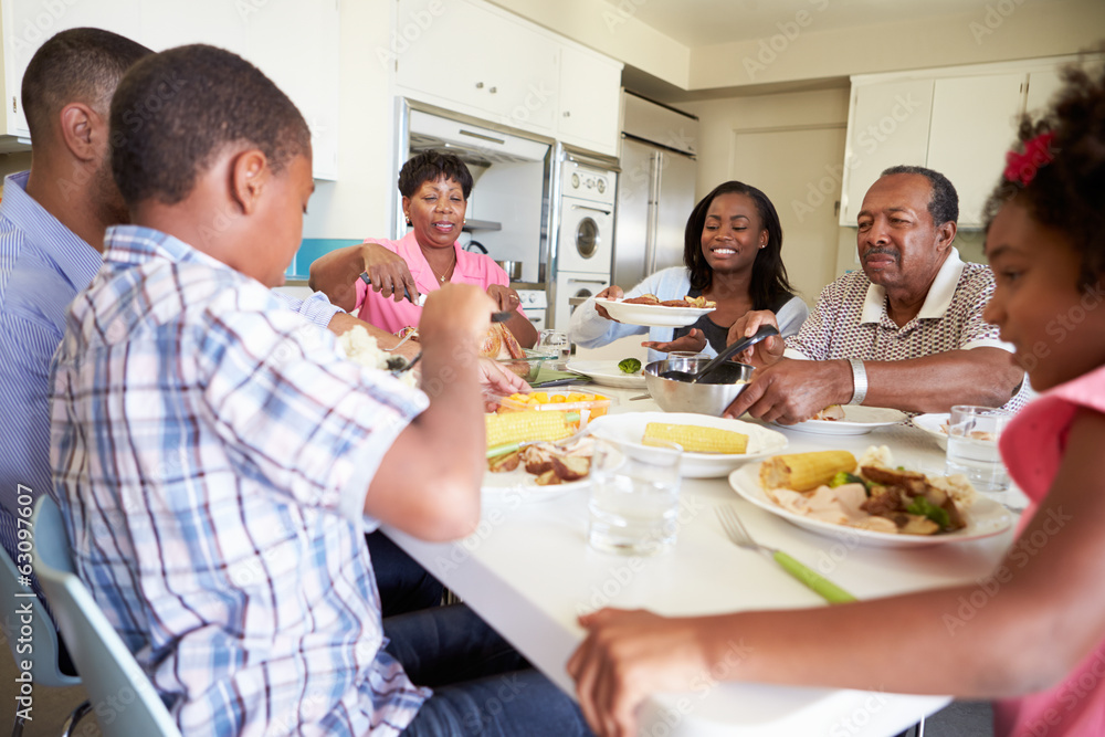 Multi-Generation Family Sitting Around Table Eating Meal Multi-Generation Family Sitting Around Table Eating Meal