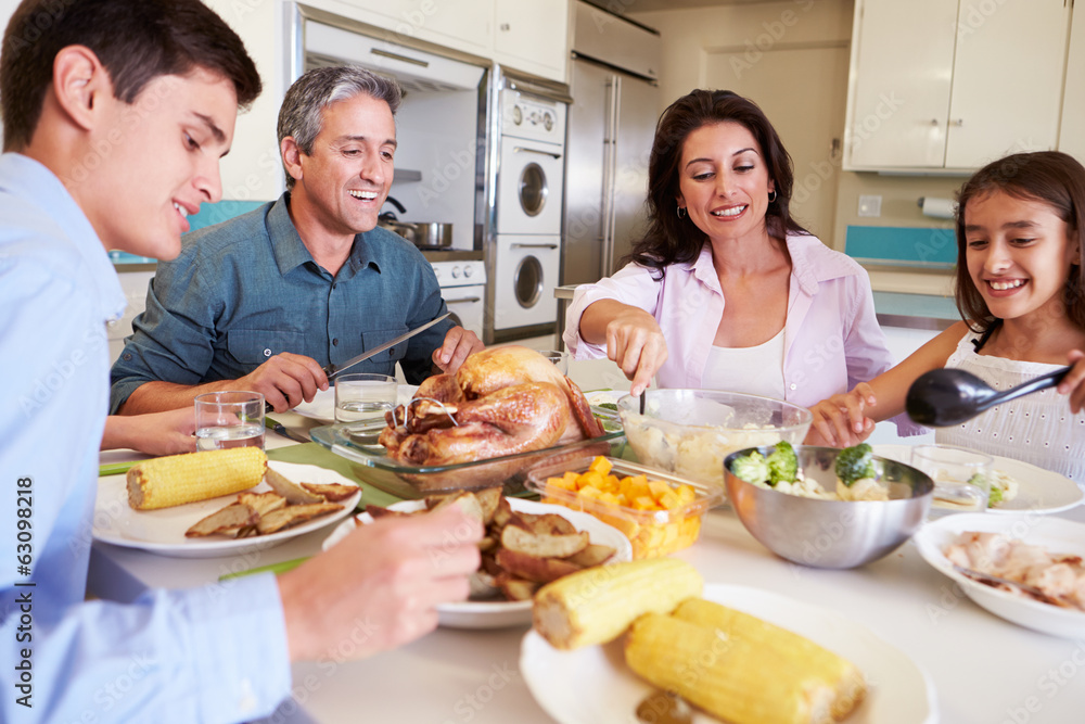 Family Sitting Around Table At Home Eating Meal