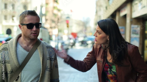 Relationship difficulties: arguing couple walking along the stre