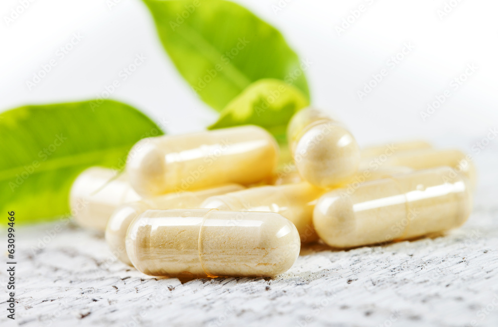 Capsules on white wooden background. Capsules on white wooden background.