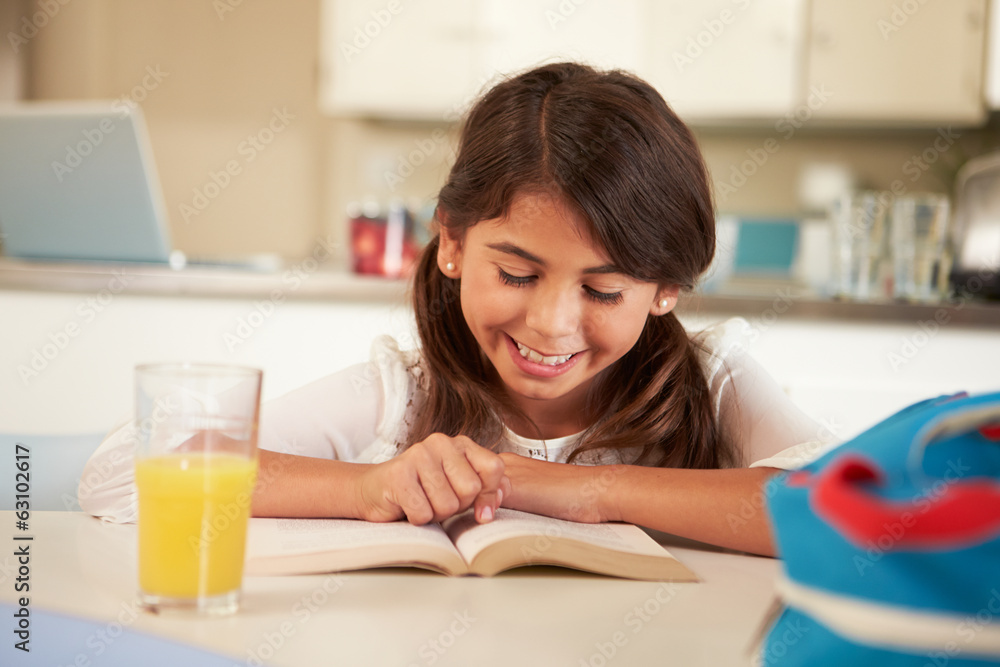 Hispanic Girl With Reading Homework At Table Hispanic Girl With Reading Homework At Table