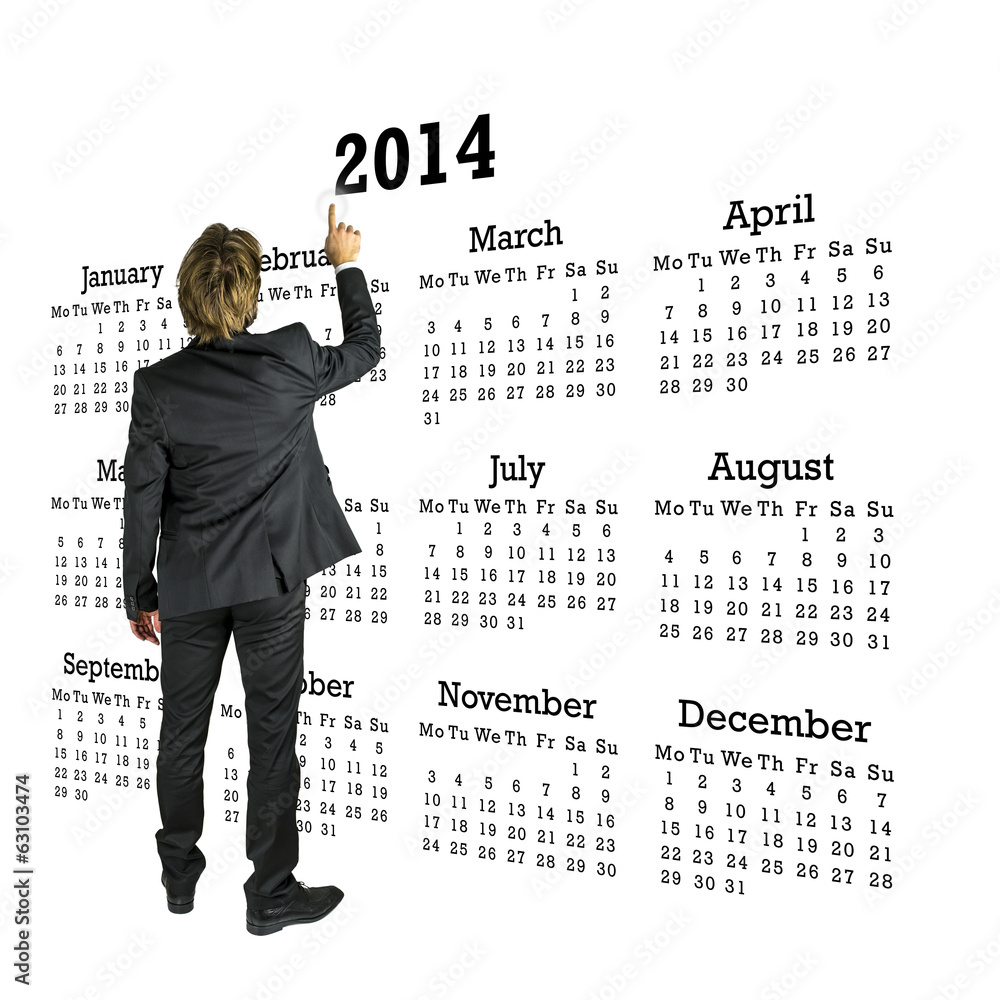 Businessman standing in front of a 2014 calendar Businessman standing in front of a 2014 calendar