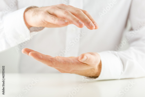 Man cupping his hands in a protective gesture