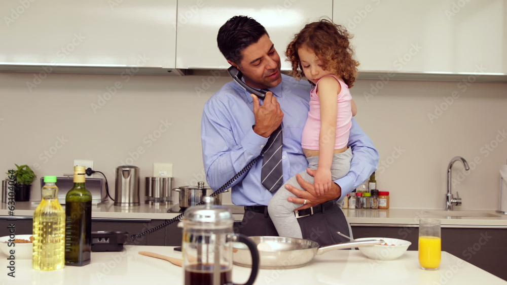 Smiling father holding his young daughter talking on the phone Smiling father holding his young daughter talking on the phone
