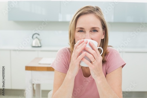 Relaxed woman having coffee in kitchen
