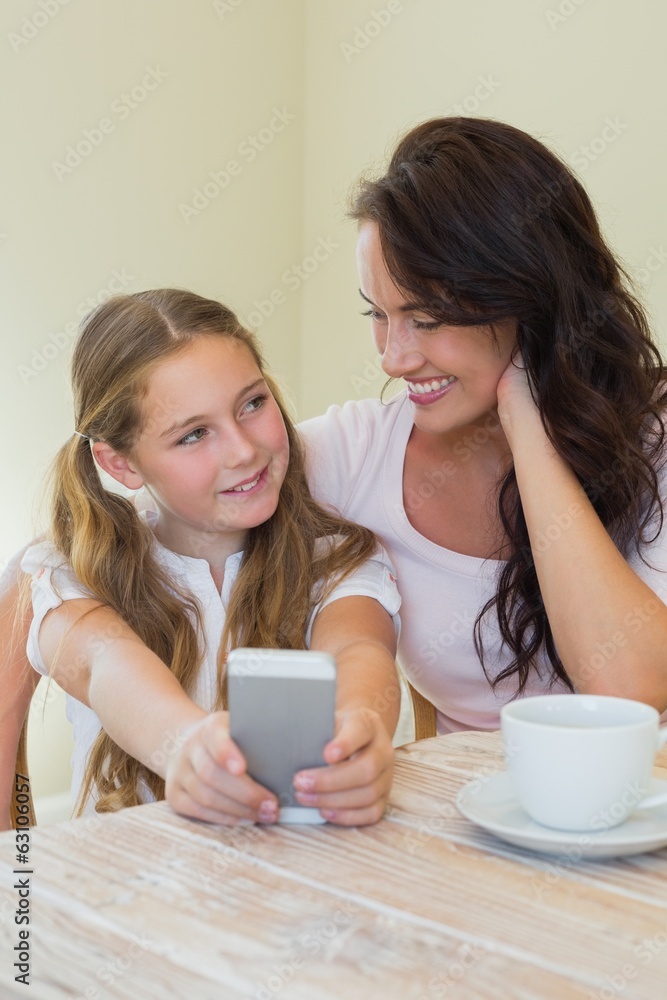 Girl with mother photographing through mobile phone Girl with mother photographing through mobile phone