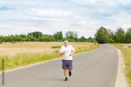 Fat man running on a rural road