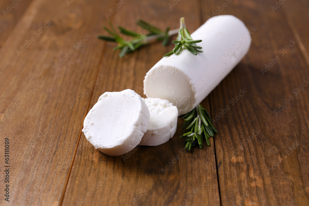 Tasty bushe cheese with rosemary, on wooden table Tasty bushe cheese with rosemary, on wooden table