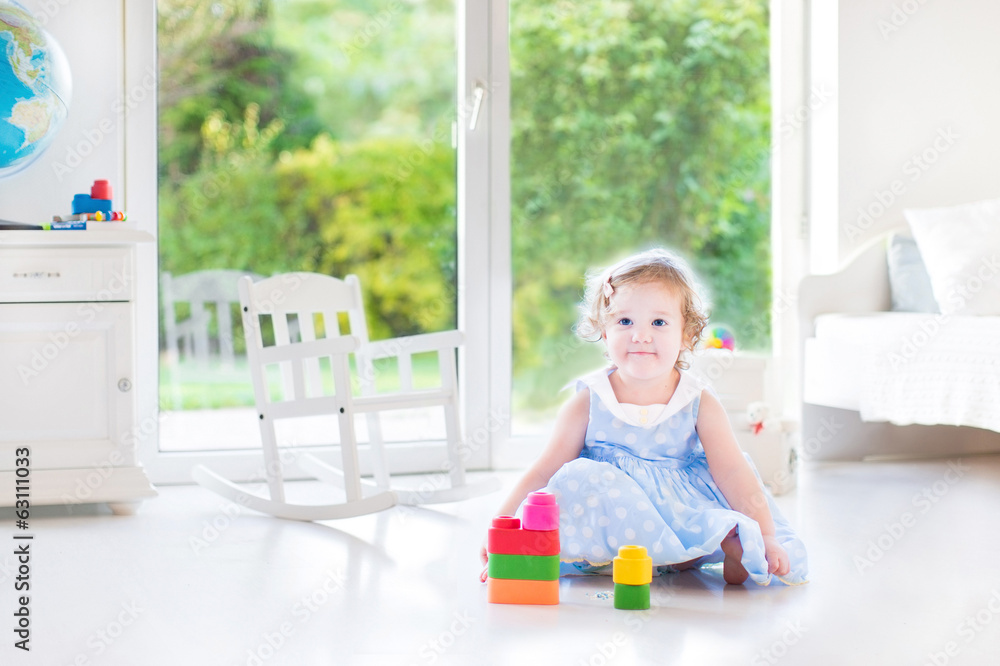 Cute toddler girl with curly hair wearing a blue dress Cute toddler girl with curly hair wearing a blue dress