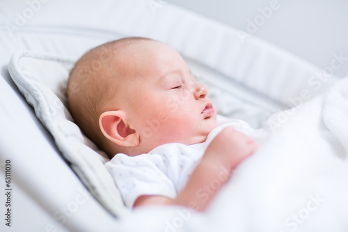 Portrait of a newborn baby sleeping in a bouncer chair