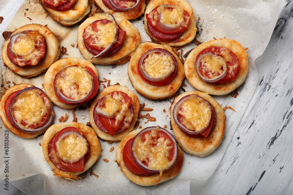 Small pizzas on baking paper close up Small pizzas on baking paper close up