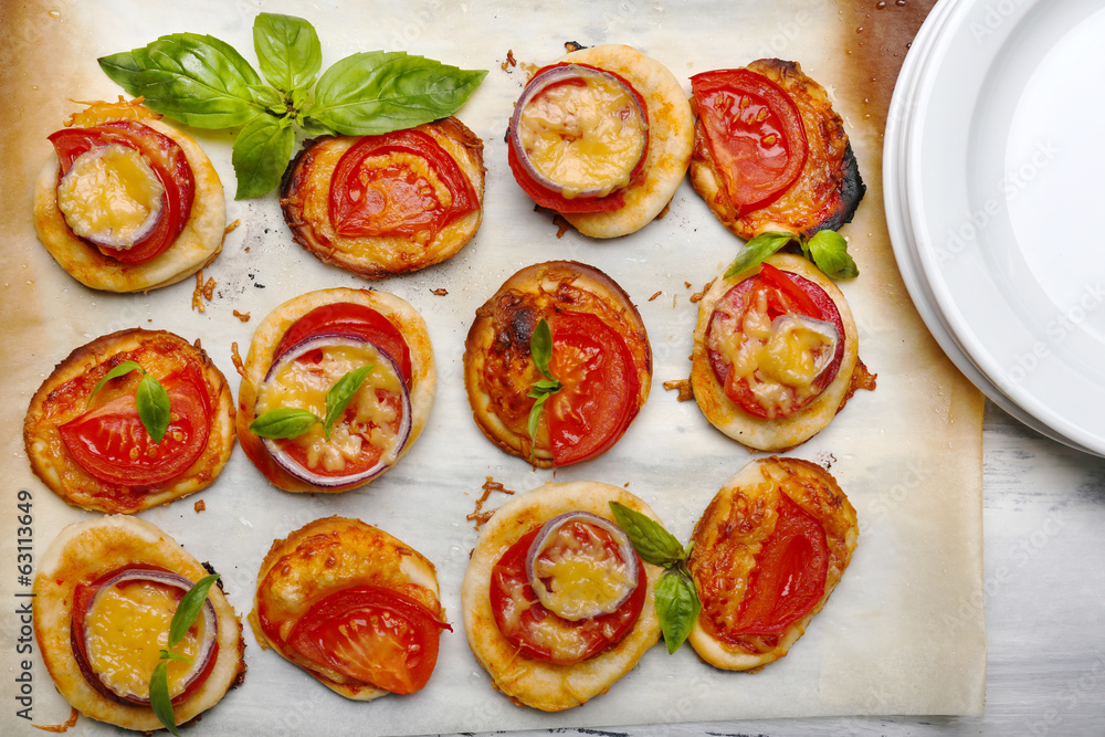 Small pizzas on baking paper close up Small pizzas on baking paper close up