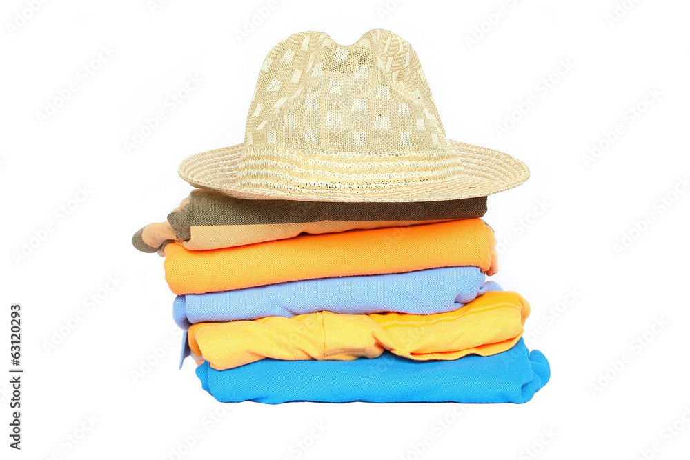 Pile of colorful clothes with a hat over white background