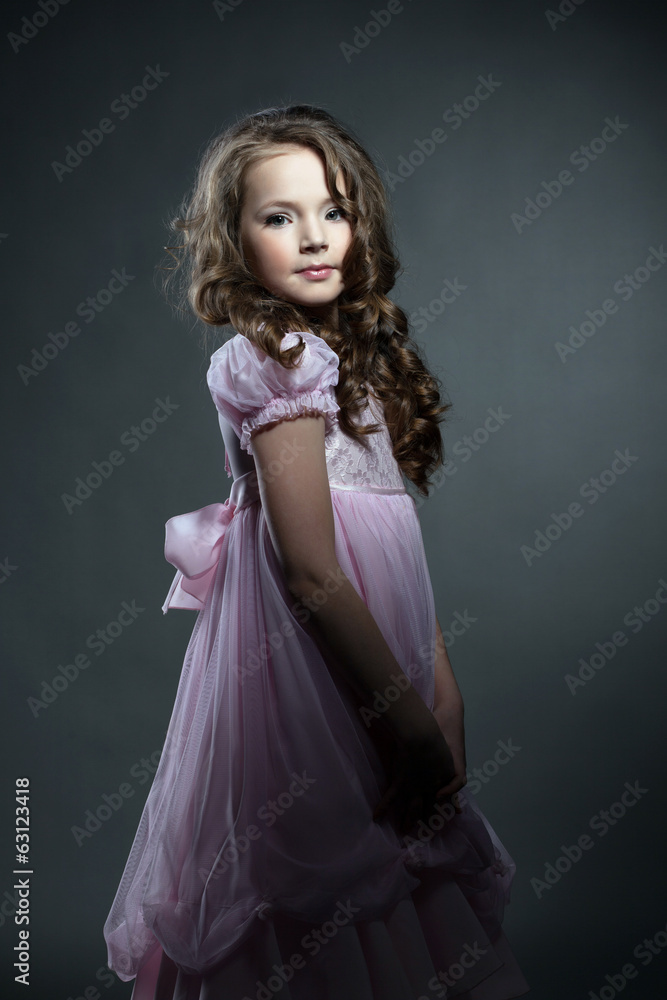 Obraz premium Adorable little girl posing in pink smart dress
