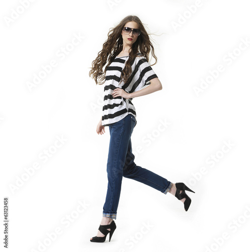 young woman in sunglasses with brown long hairs walking