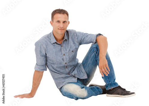 A handsome young man sitting on the floor