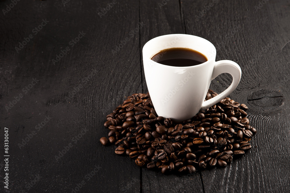 cup of coffee and coffee beans over dark background cup of coffee and coffee beans over dark background