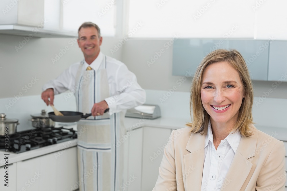 Obraz premium Businesswoman with man preparing food in kitchen