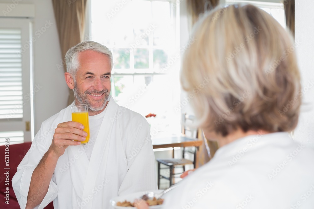 Smiling mature man having breakfast with cropped woman Smiling mature man having breakfast with cropped woman