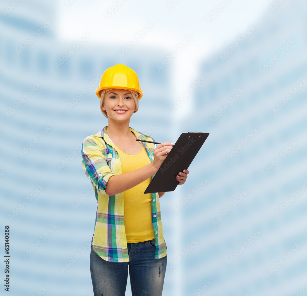 smiling woman in helmet with clipboard smiling woman in helmet with clipboard
