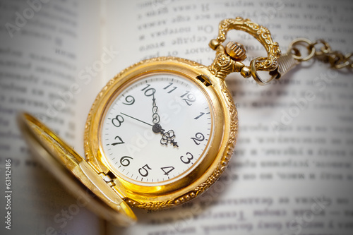 vintage pocket watch lying on the book, retro style