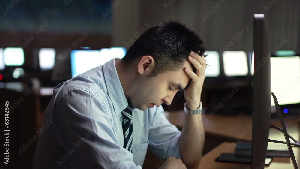 Annoyed businessman sitting in front of computer monitor Annoyed businessman sitting in front of computer monitor